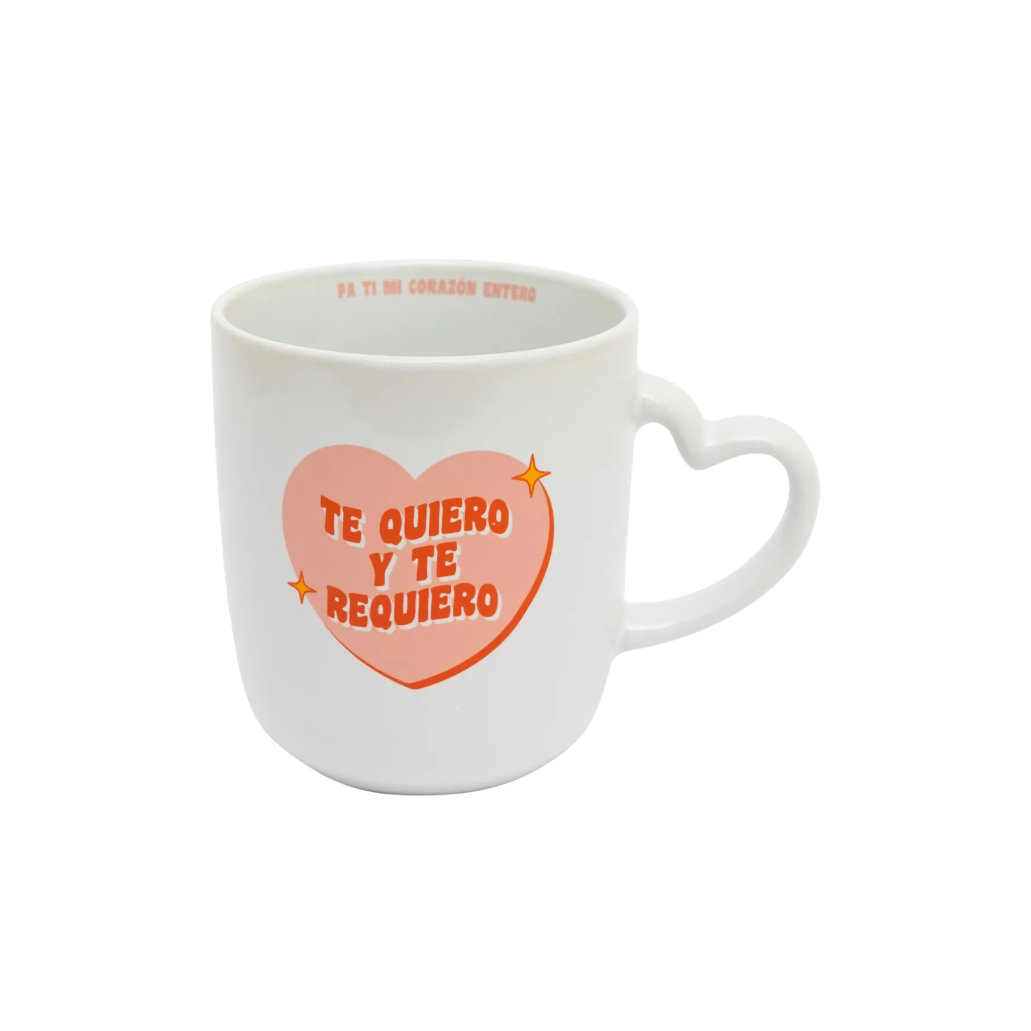 White ceramic mug with a heart-shaped handle and a peach-pink heart graphic that reads ‘Te quiero y te requiero’; additional Spanish message printed inside the rim; 12-oz.