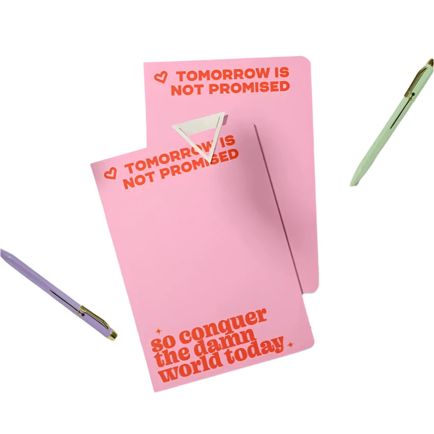 Pink pocket-sized journal that says “Tomorrow is not promised, so conquer the damn world today” from Funky Confetti