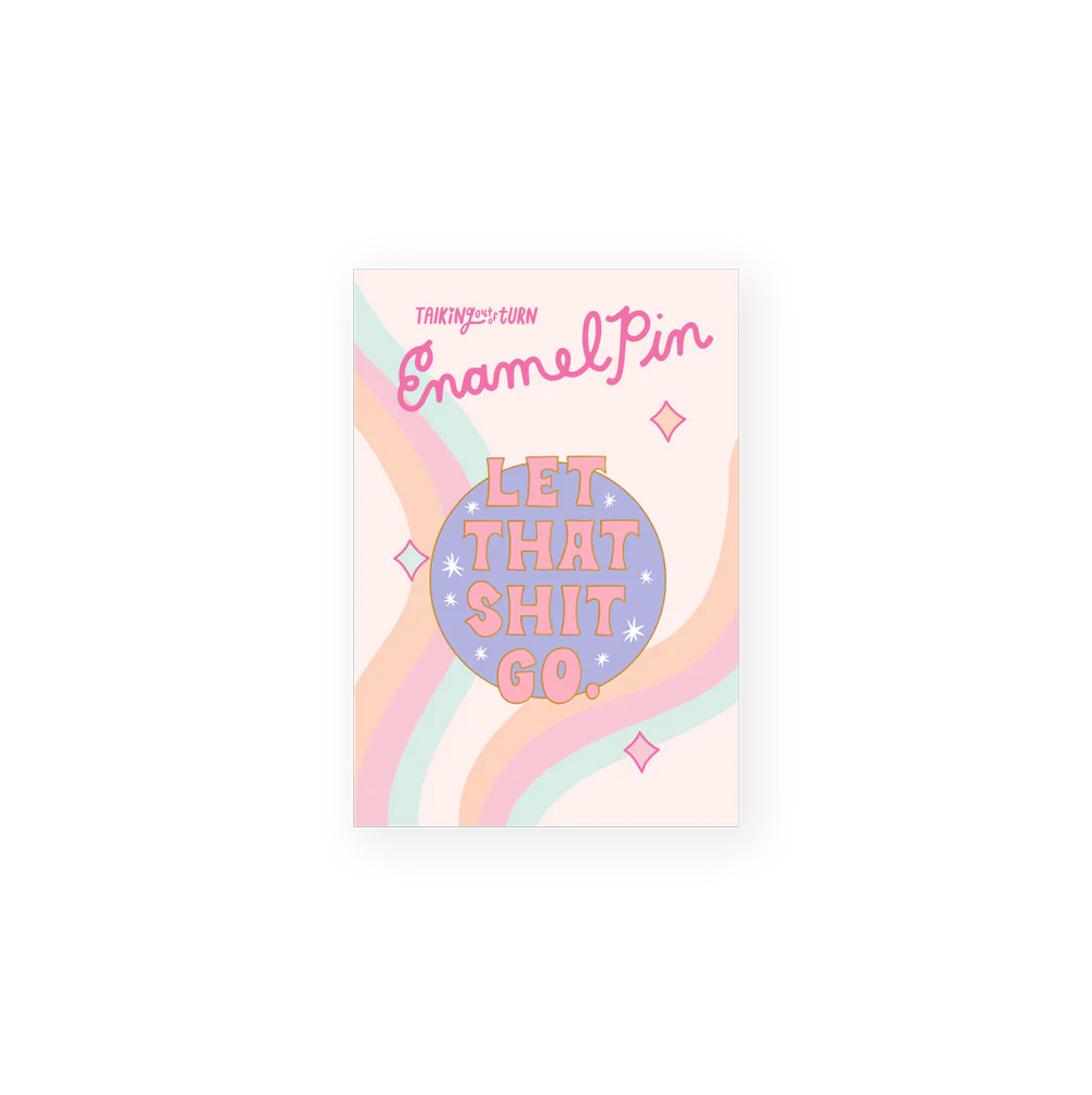 Pastel enamel pin on backing card—round lavender pin with stars that reads “LET THAT SHIT GO,” on a card with wavy rainbow stripes and “Enamel Pin” text.