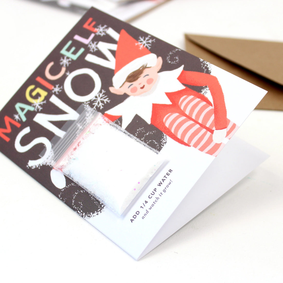 Christmas greeting card featuring an elf illustration and instant snow packet labeled “Magic Elf Snow” – Funky Confetti