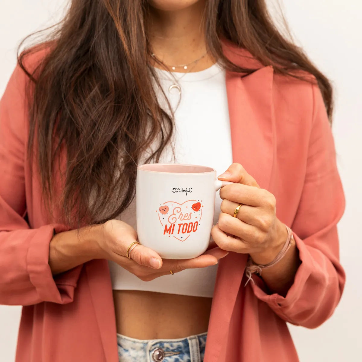 Person holding the “Eres mi todo” mug; cream exterior with blush handle and interior.