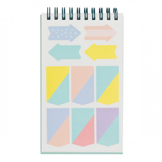 Spiral-bound sticker book open to pastel arrows and tabs sheet.