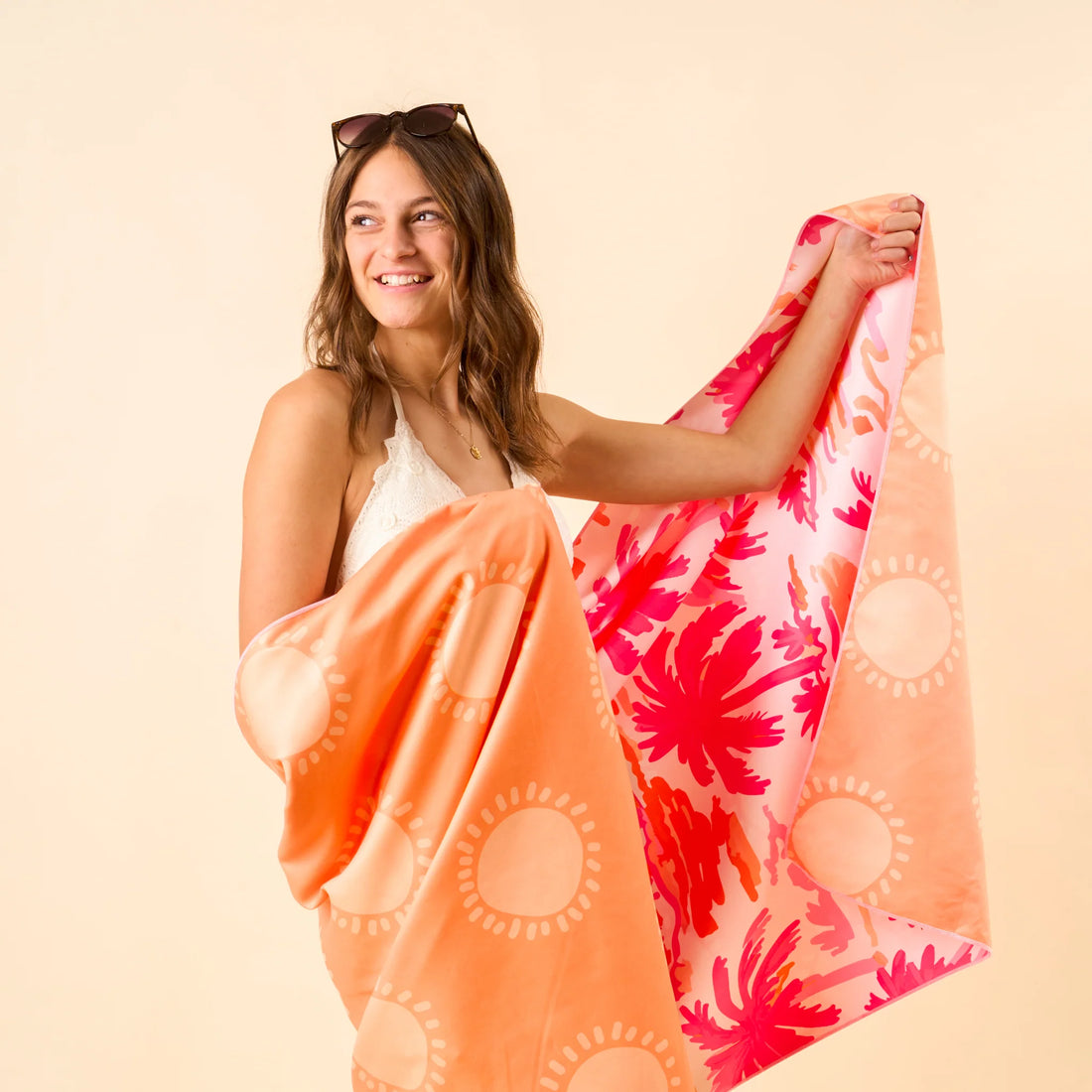 Tropical palm print XL quick-dry microfiber beach towel in pink and orange with matching drawstring bag from Funky Confetti