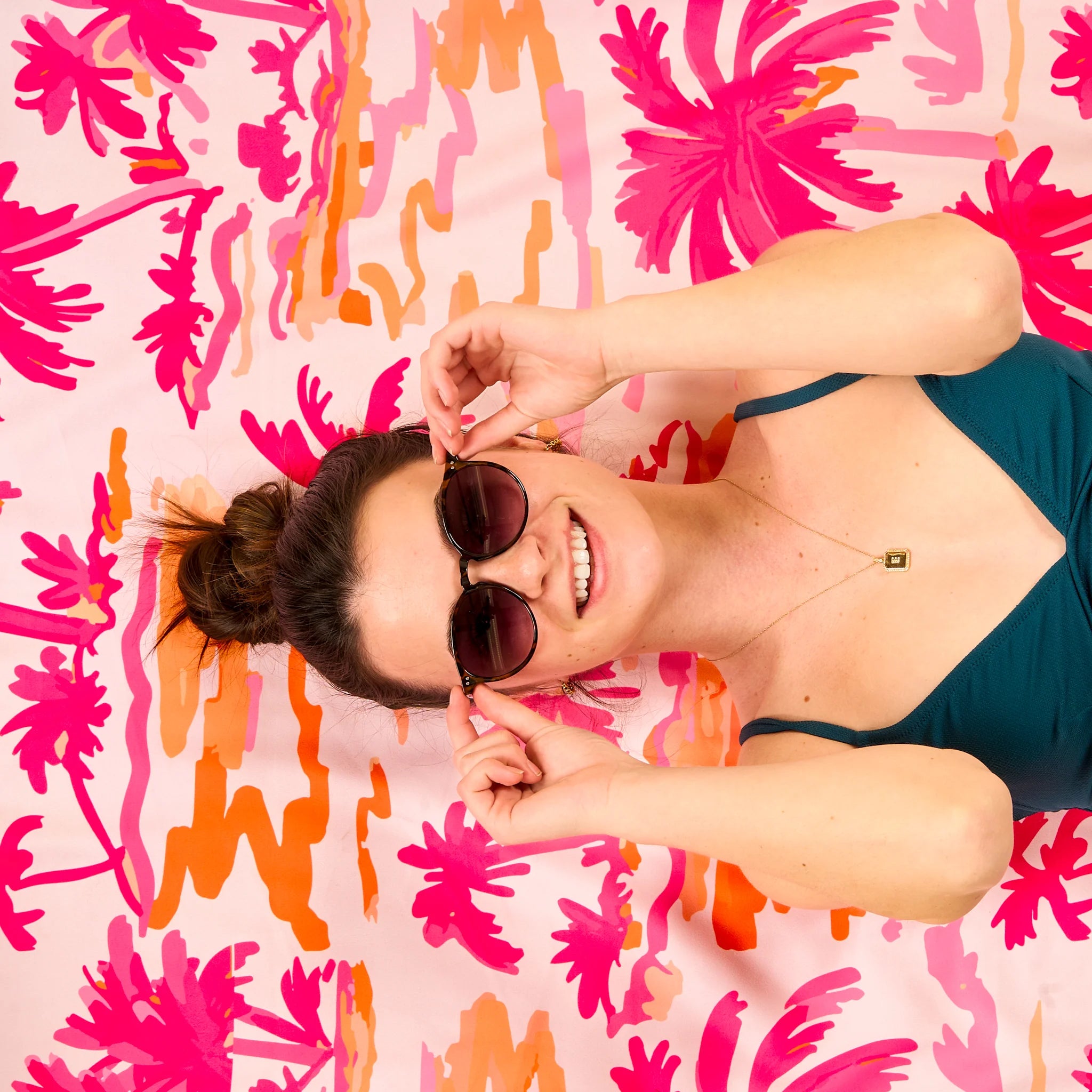 Tropical palm print XL quick-dry microfiber beach towel in pink and orange with matching drawstring bag from Funky Confetti