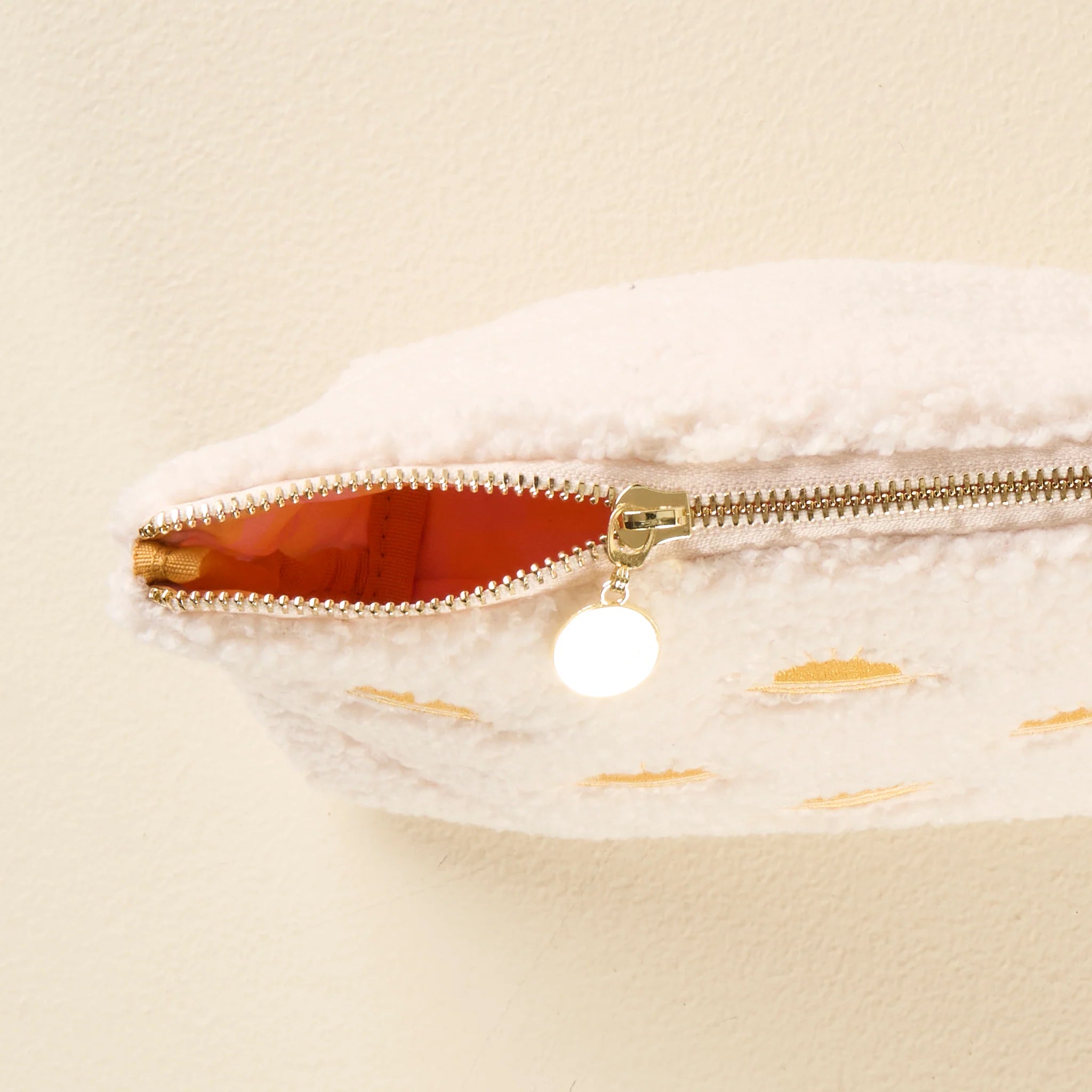 Cream sherpa teddy pouch with embroidered yellow sun pattern and gold zipper from Funky Confetti
