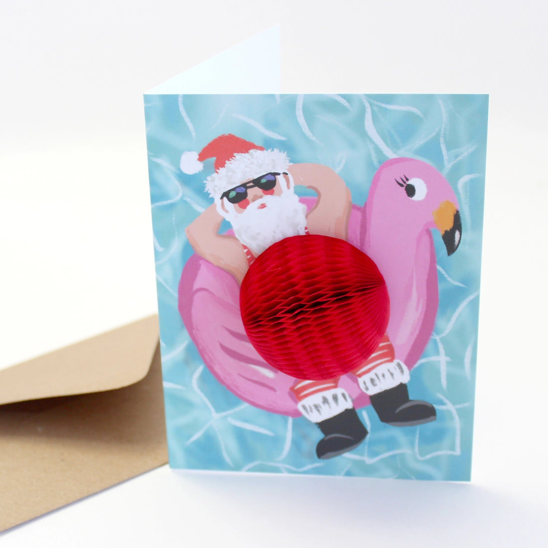 Christmas greeting card featuring Santa relaxing on a pink flamingo float with a 3D red honeycomb belly – Funky Confetti